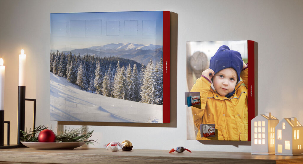 A beautiful CEWE photo calendar with winter landscape images on the wall.