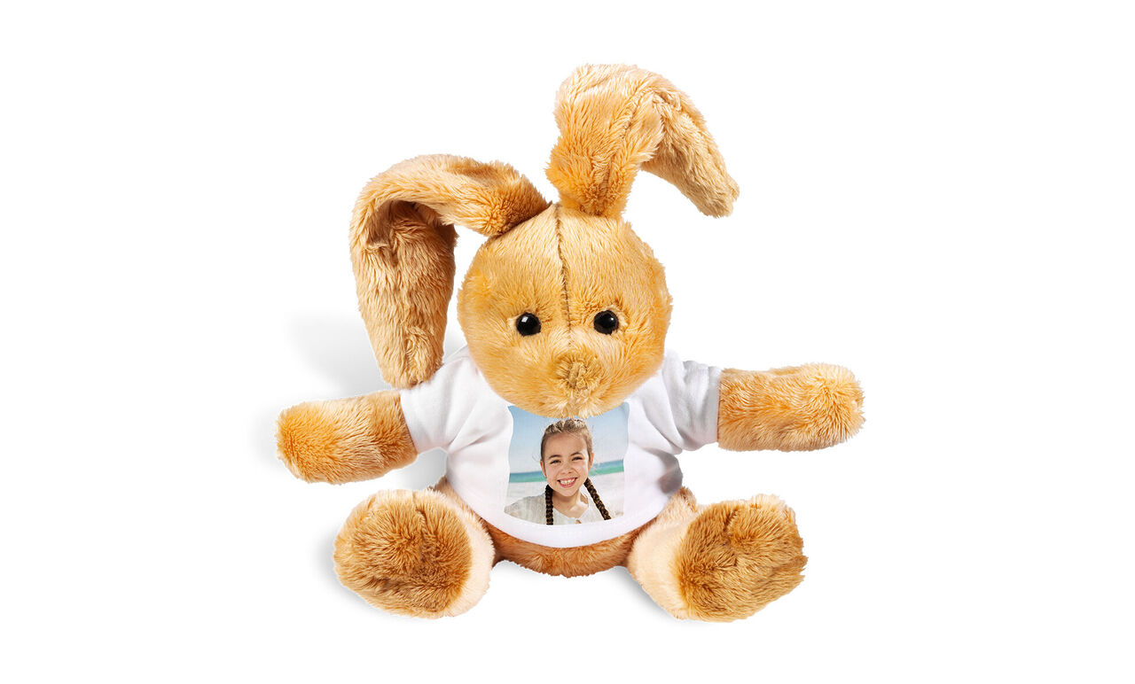 A lovely brown plush bunny with soft ears wearing a white shirt with a photo on the front.