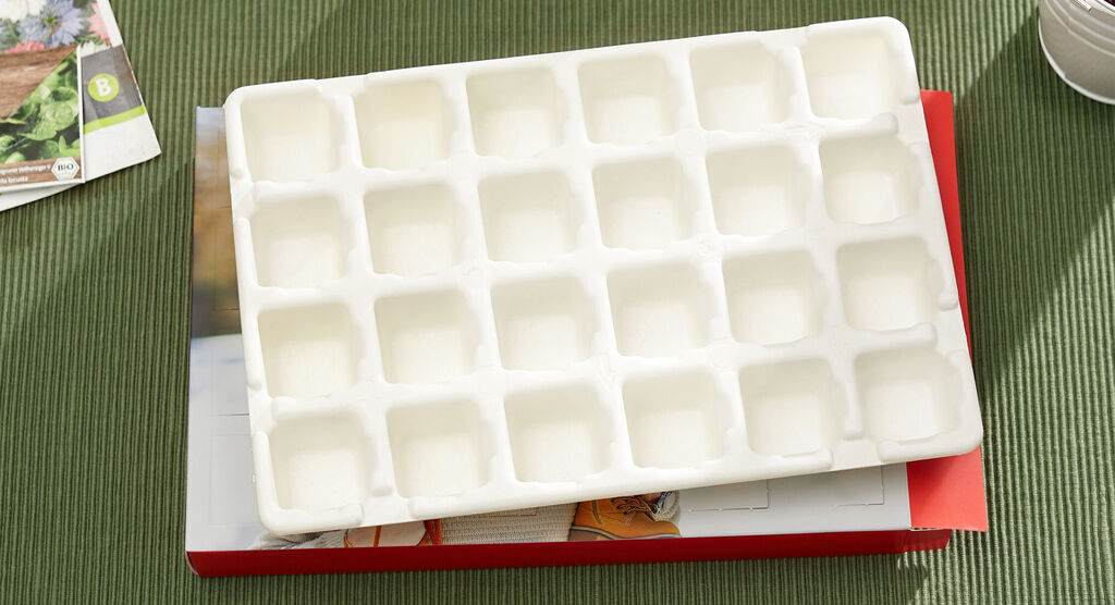 A white ice cube tray on a colorful magazine.