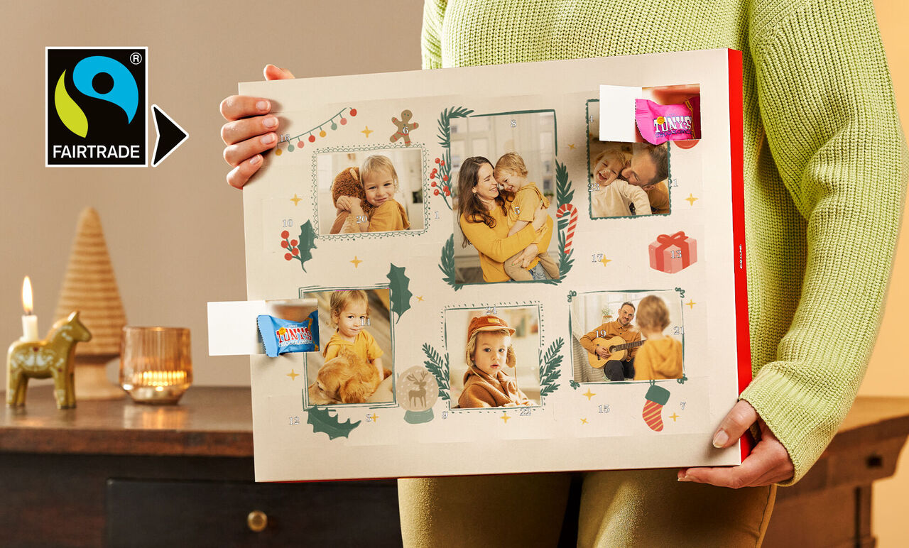A person holds a beautiful photo calendar with festive images and decorations.