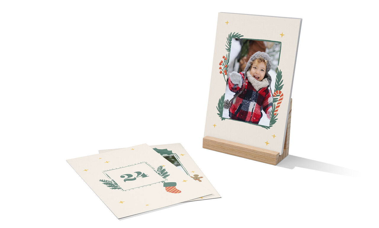 A lovingly designed picture frame made from 100% recycled paper shows a festive motif. Next to it is a decorative sheet with the number 24.